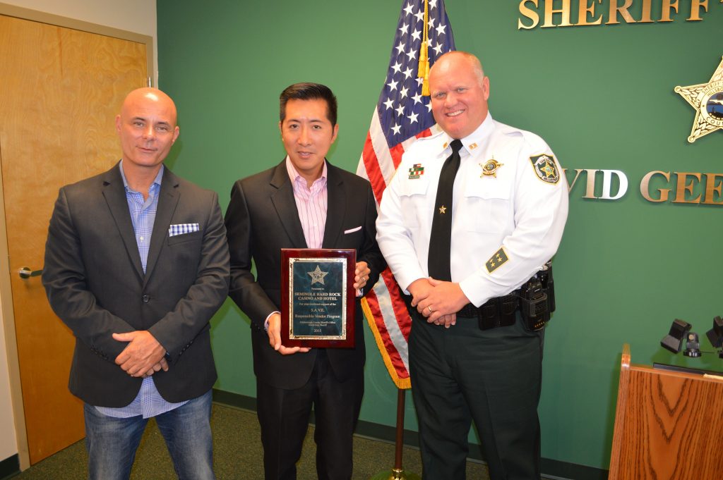   Seminole Hard Rock Tampa’s General Manager Peter Wu holds the 2015 S.A.V.E. Award. Joining Wu at the award ceremony were (left) Donny Crawley, the property’s Director of Beverage, and Captain Kyle Robinson of the Hillsborough County Sheriff’s Office. 